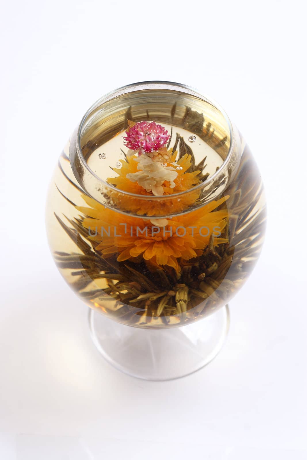 Glass with a blooming flower green tea on white background