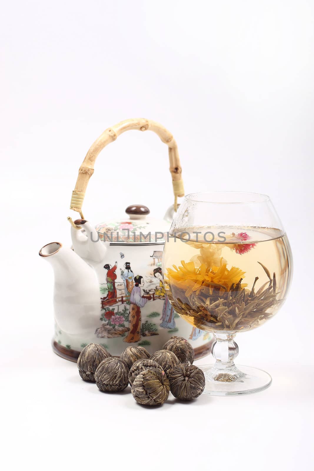 Teapot and Glass with a blooming flower green tea on white background