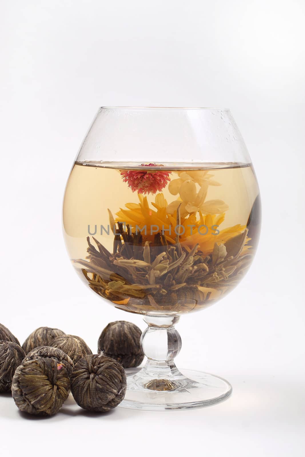 Glass with a blooming flower green tea on white background