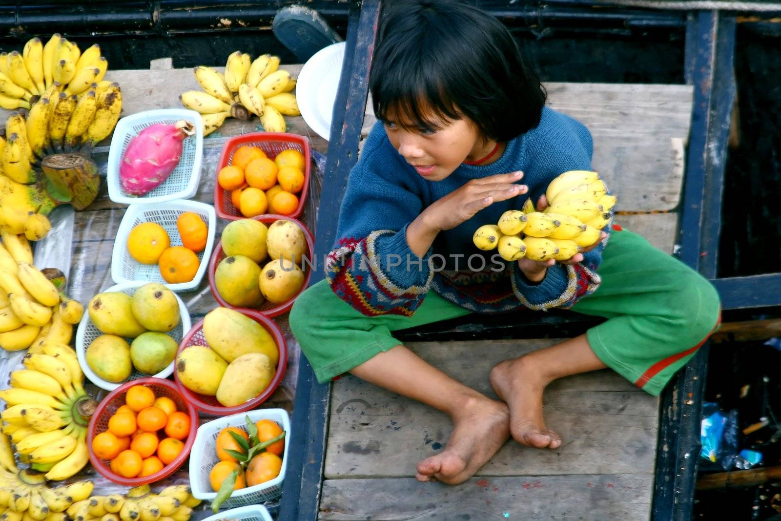 some fruits and youn boy on boat - vietnam