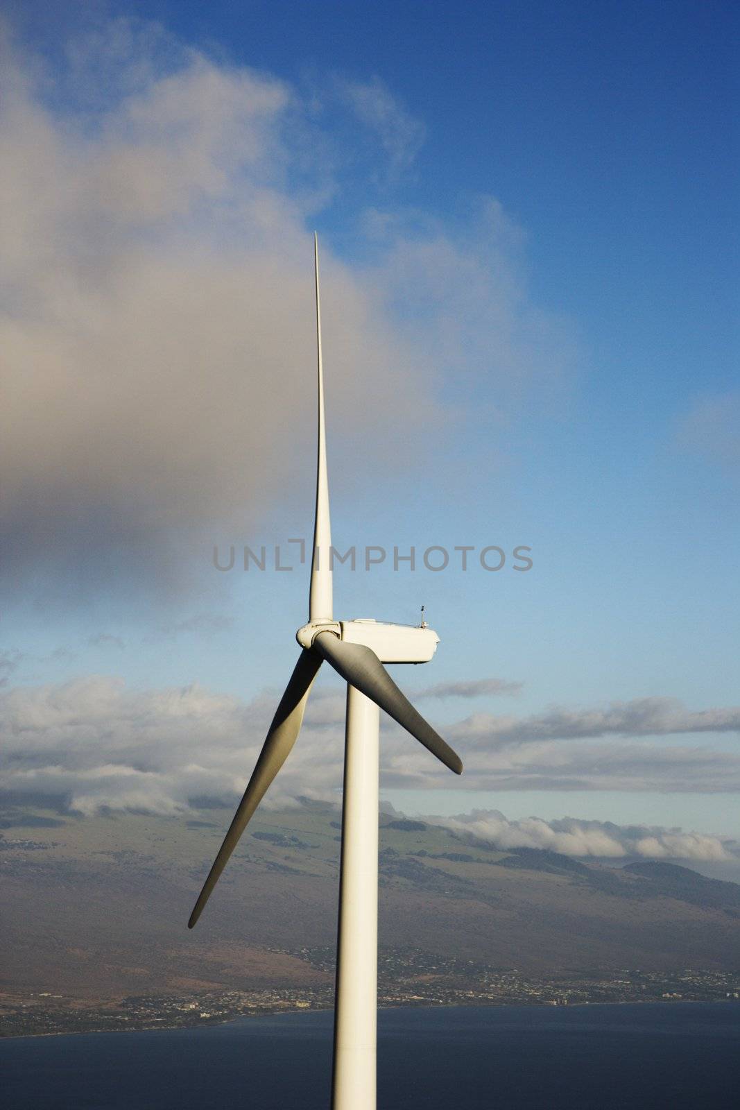 Wind turbine with Hawaiian landscape in background.