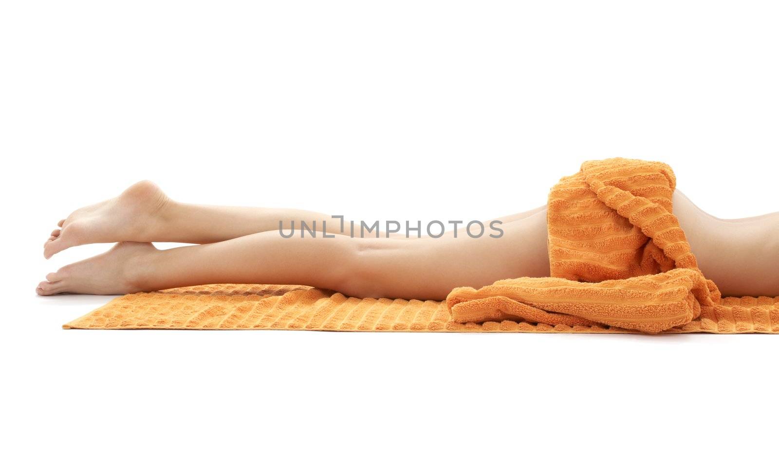 long legs of relaxed lady with orange towel over white