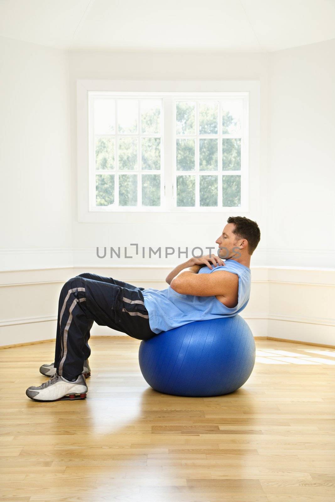 Man doing sit ups on balance ball.
