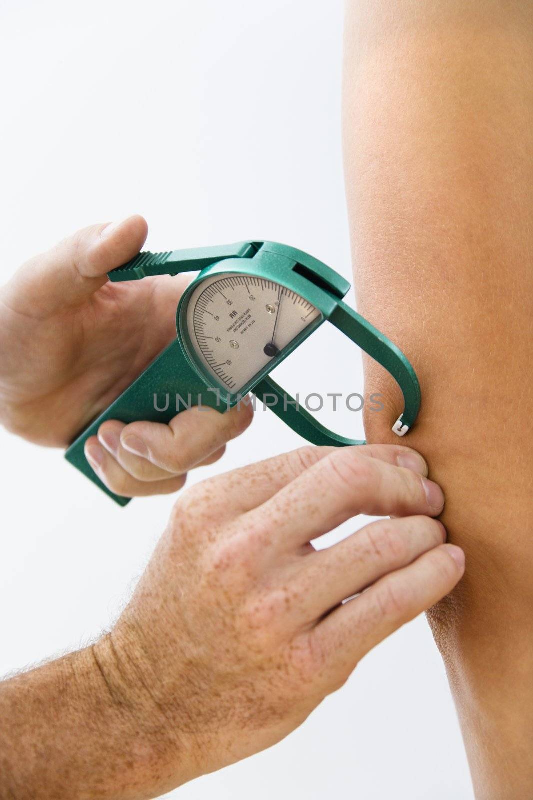 Close-up of adult male hand using caliper to test body fat.