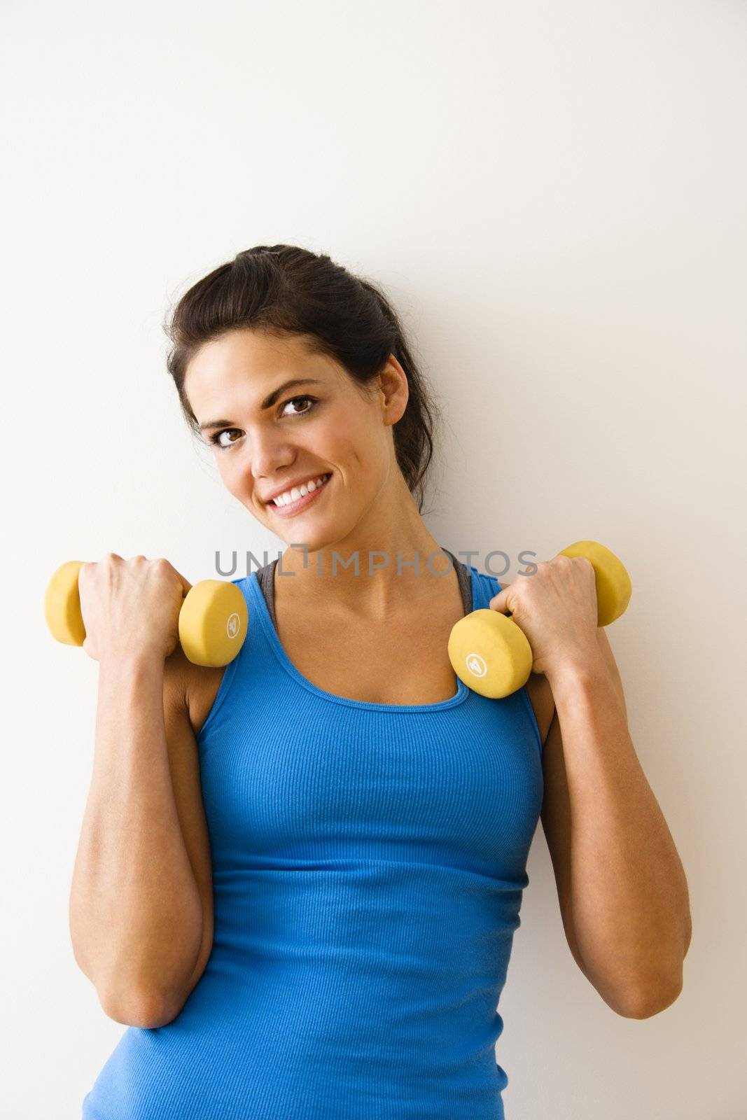 Woman holding hand weights and smiling.