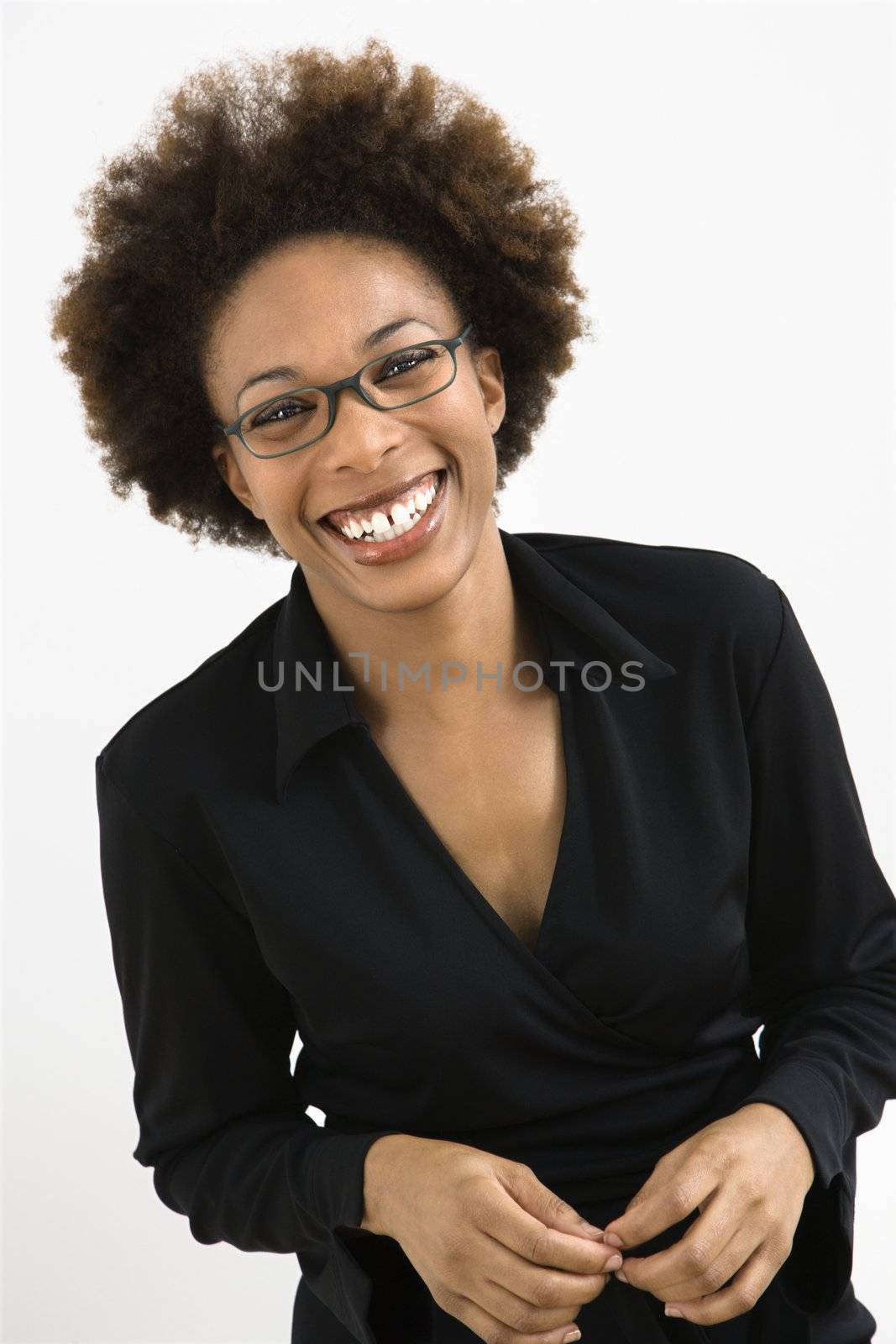 Portrait of woman with afro wearing eyeglasses against white background.