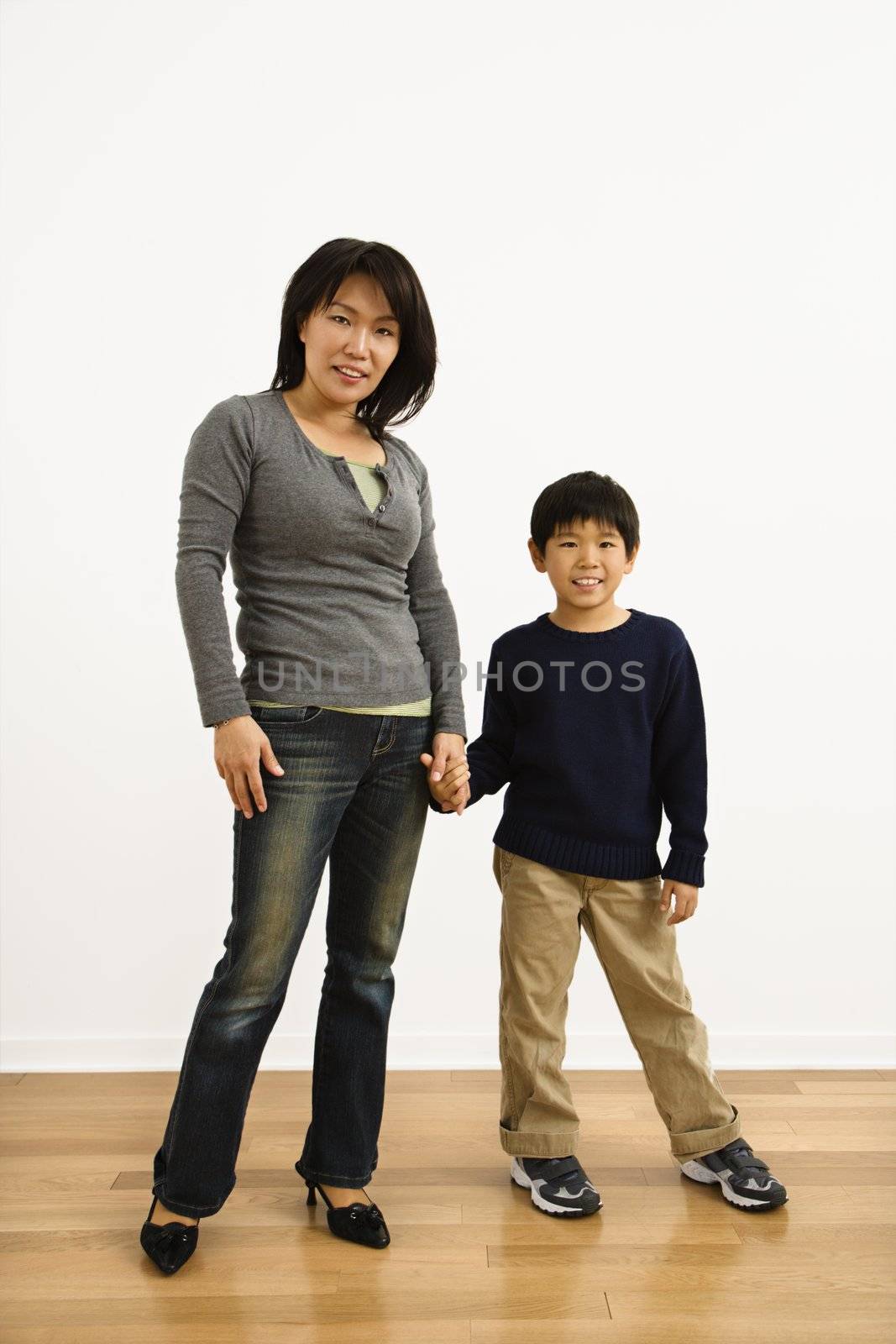 Portrait of Asian mother and son holding hands.