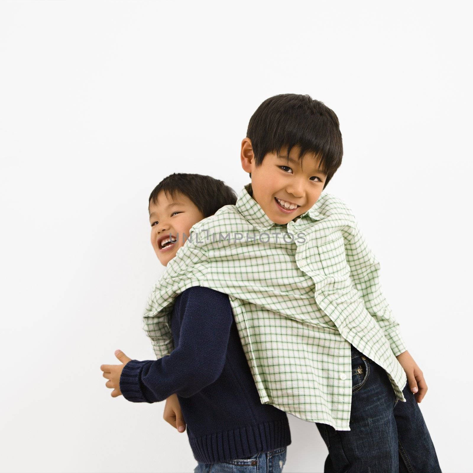Two young Asian brothers playing and laughing.