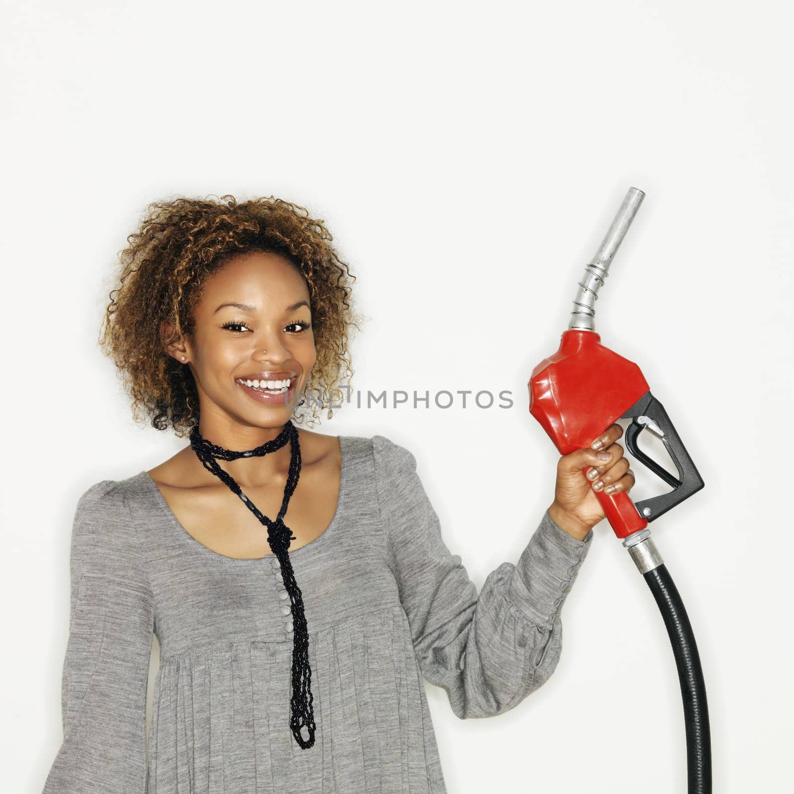 Woman holding gas nozzle by iofoto