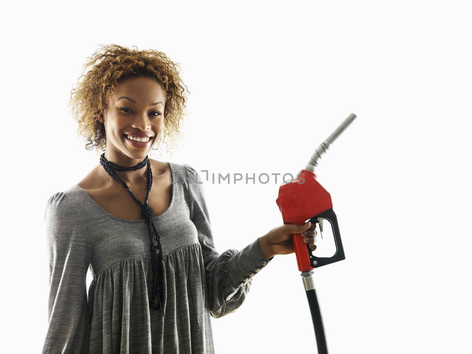 Portrait of pretty young woman smiling holding gas pump nozzle on white background.