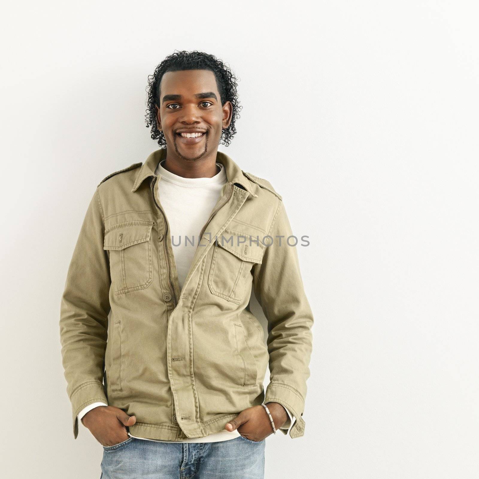 Portrait of smiling man standing against white background.