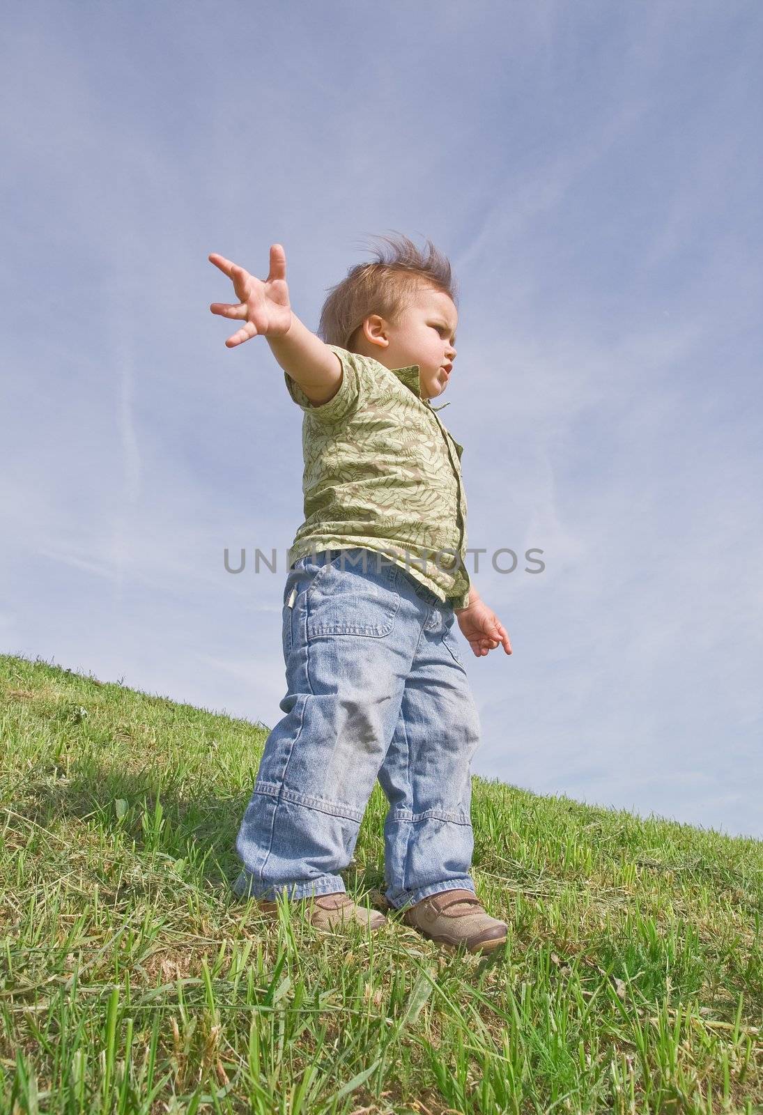 Toddler standing on a hill, view from below