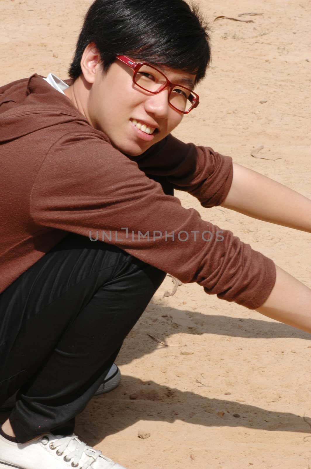 Happy young Chinese male on sandy beach