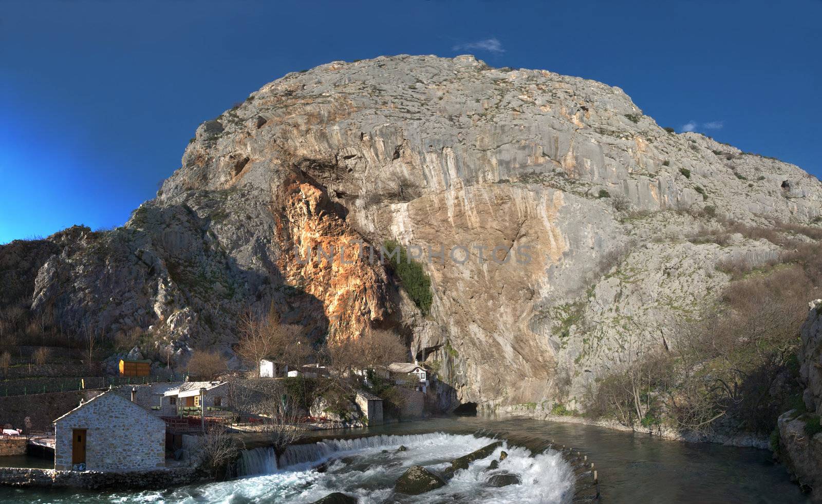 Panorama of the Buna river source near Mostar in Bosnia and Herzegovina with water coming out of a cave. Just above the cave is an old muslim school turned in a national monument. 