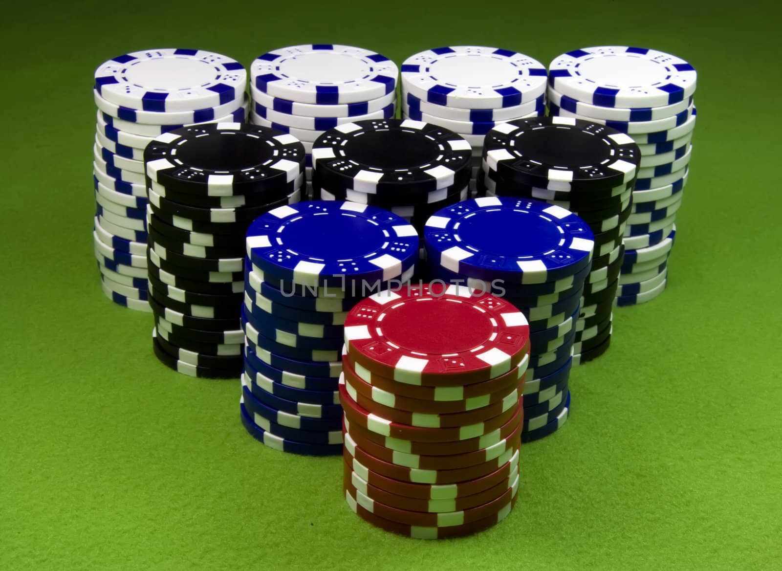 Very big casino chips stack over green table