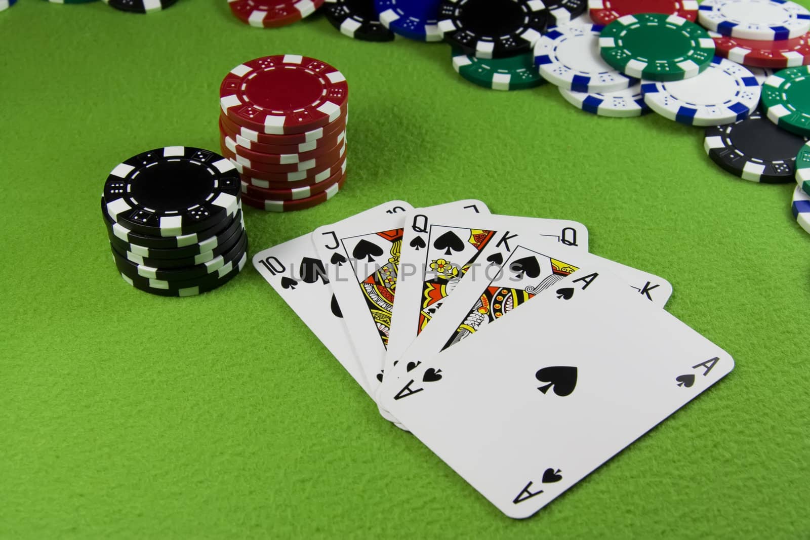 Royal flush in poker cards, chips green table