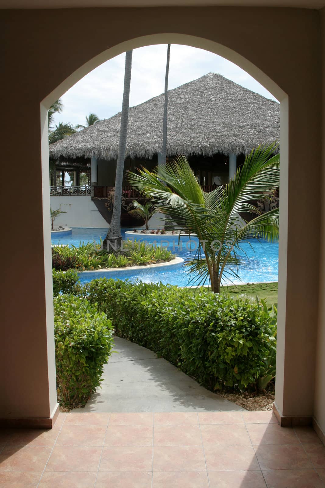 A tropical resort through the view of an archway. 