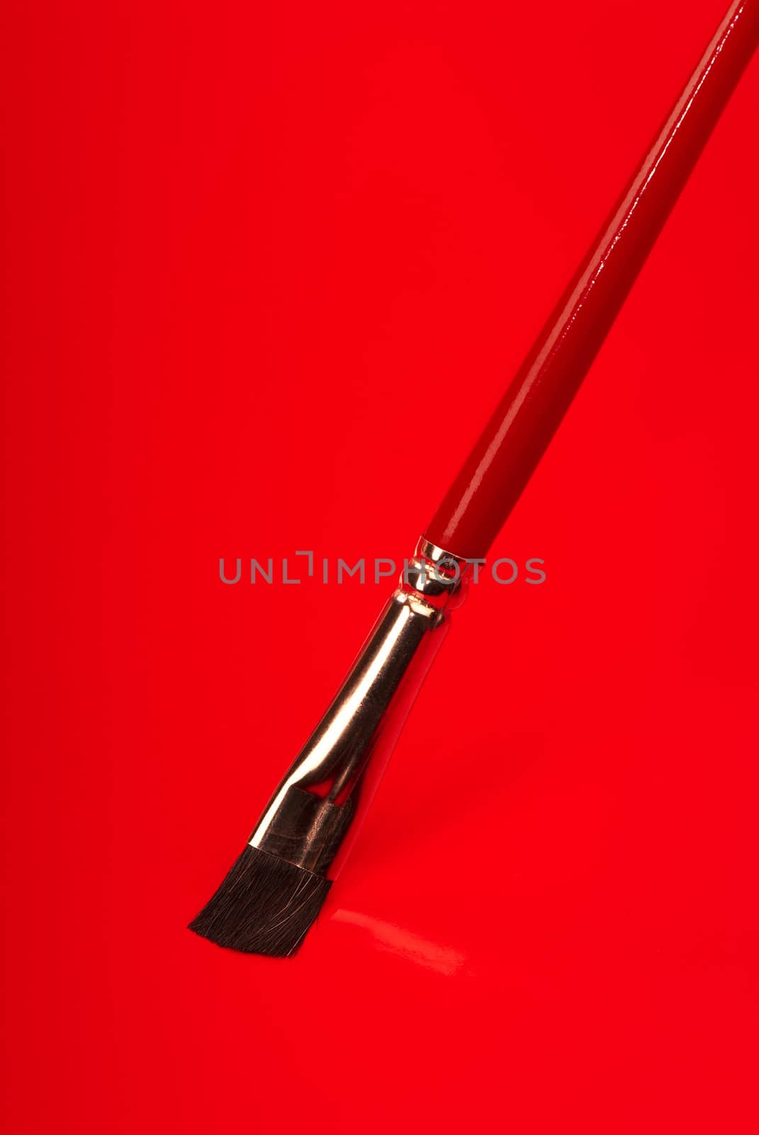 Red paintbrush on a red background