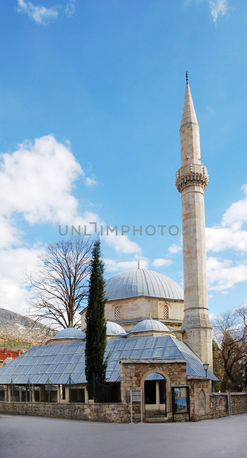 Karadjozbeg Mosque in Mostar, Bosnia and Herzegovina with blue sky in background.
