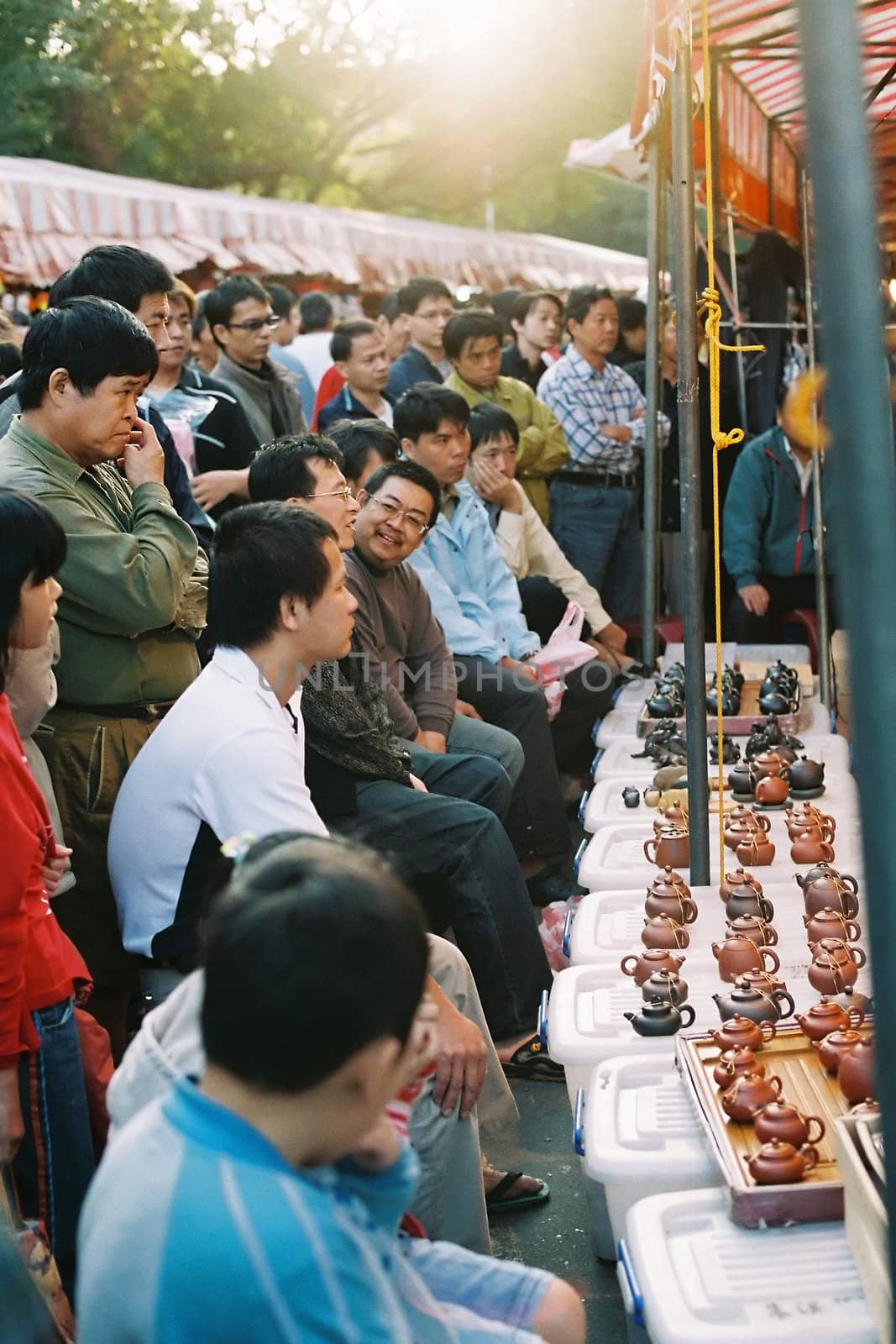 Crowd is attracted by a stall that sold chinese style tea pot, in a late afternoon local market of Hsinchu city, Taiwan. A glance of daily life of people in Taiwan.