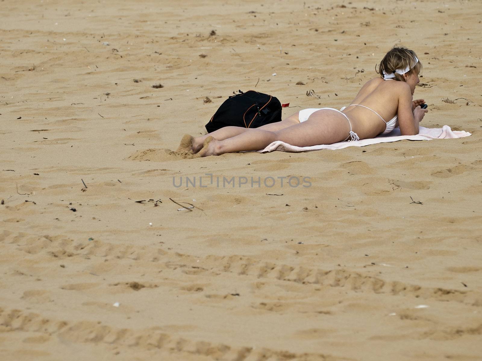 Woman in bikini relaxing on a beach on the Mediterranean island of Malta