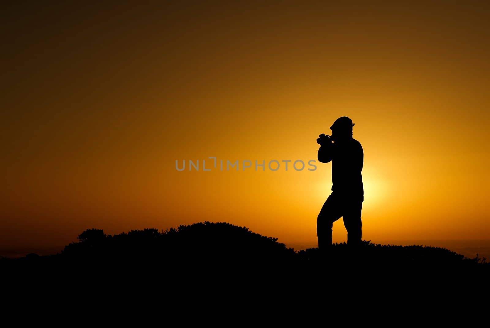 A silhouette of cameraman with golden light in the morning.