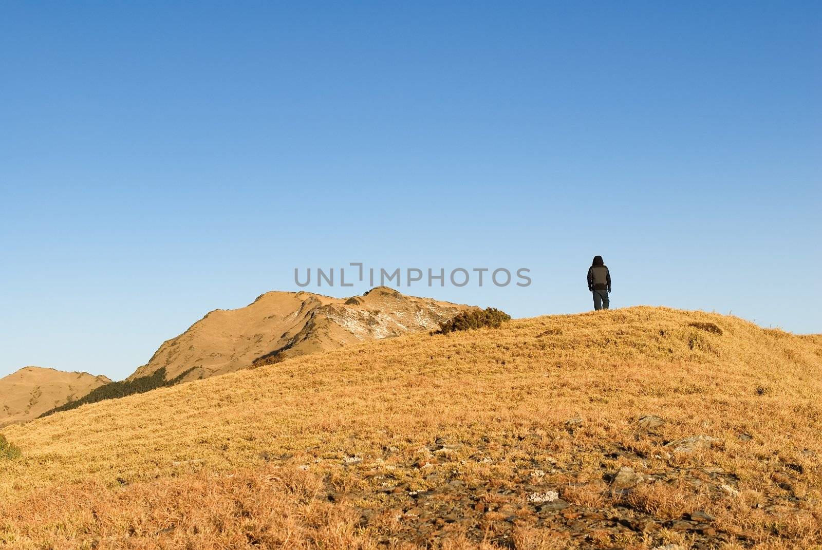 A man stand on the mountain with golden sunshine.