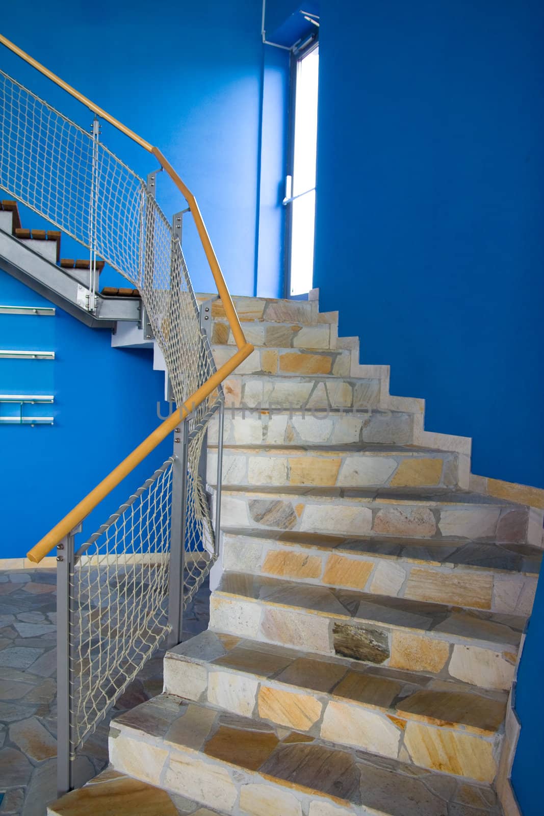 Staircase with blue walls and fence going upstairs.