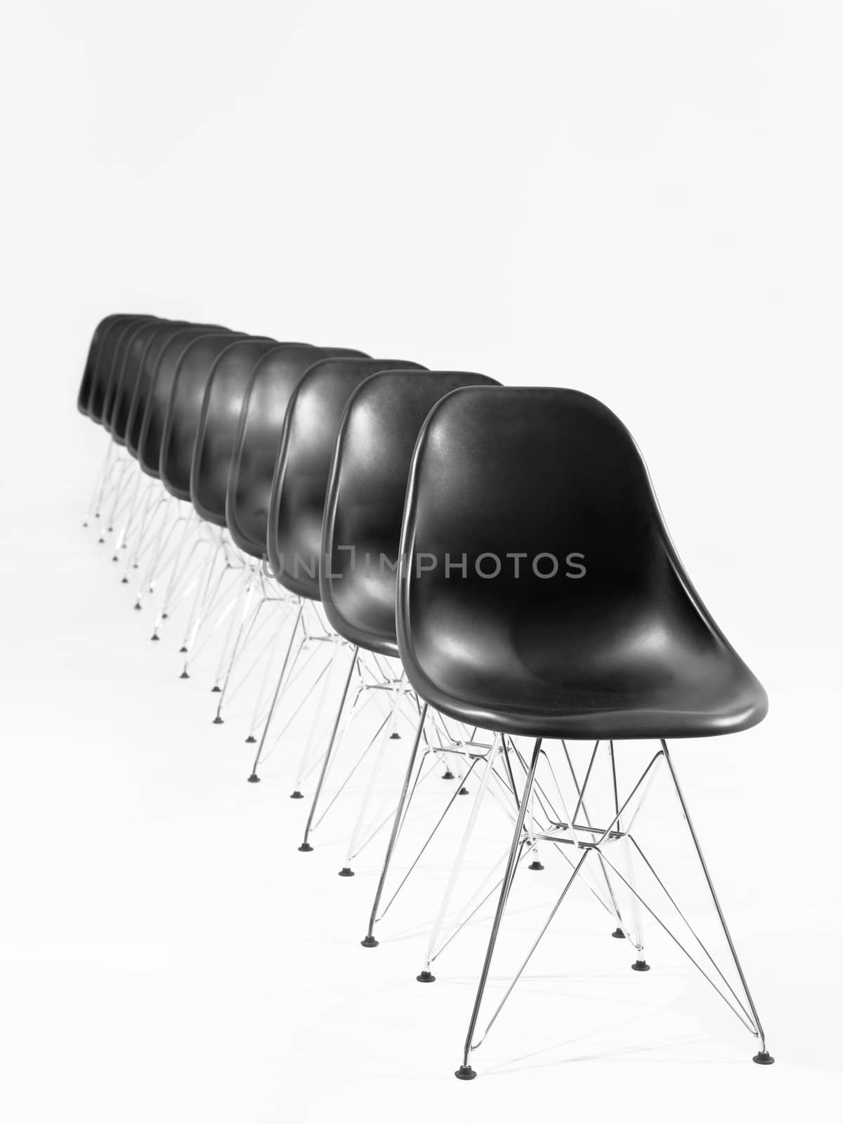 Black chairs in a row isolated on white background