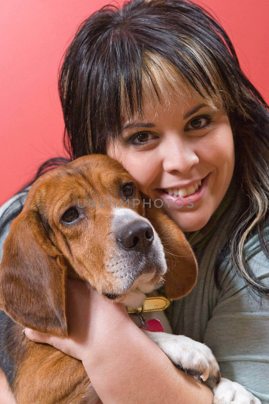 A pretty young woman posing with her beagle pup.  Shallow depth of field.