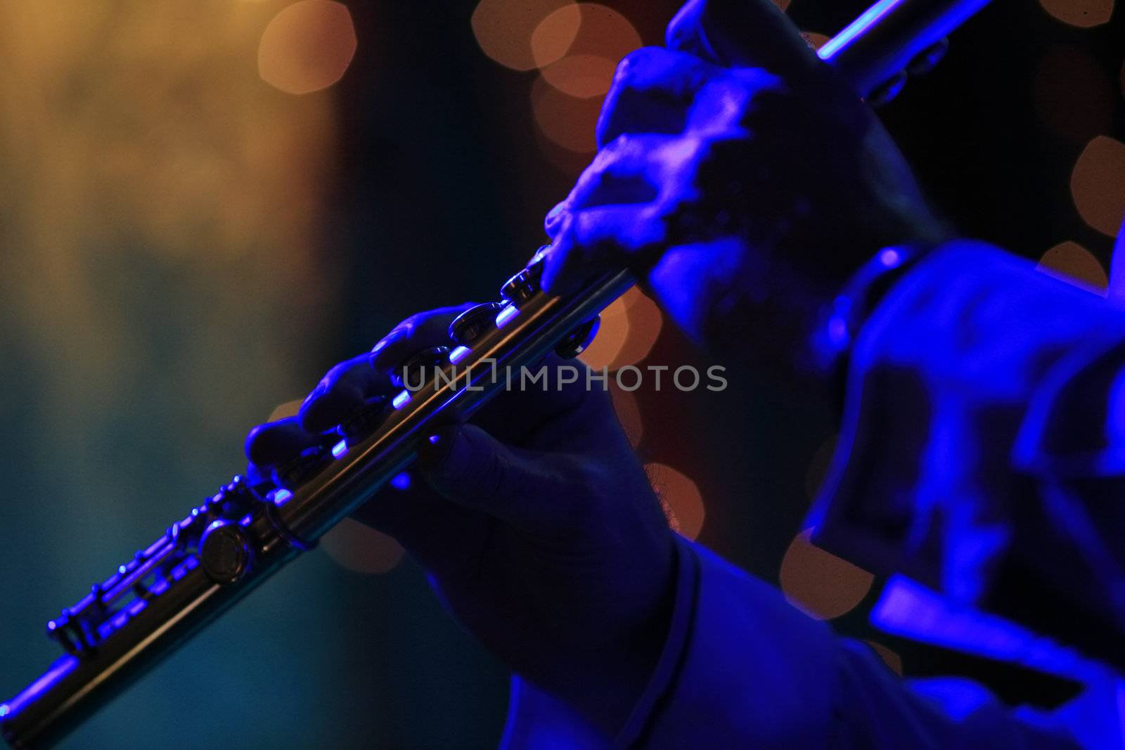 Flute in hands of the musician with scenic light