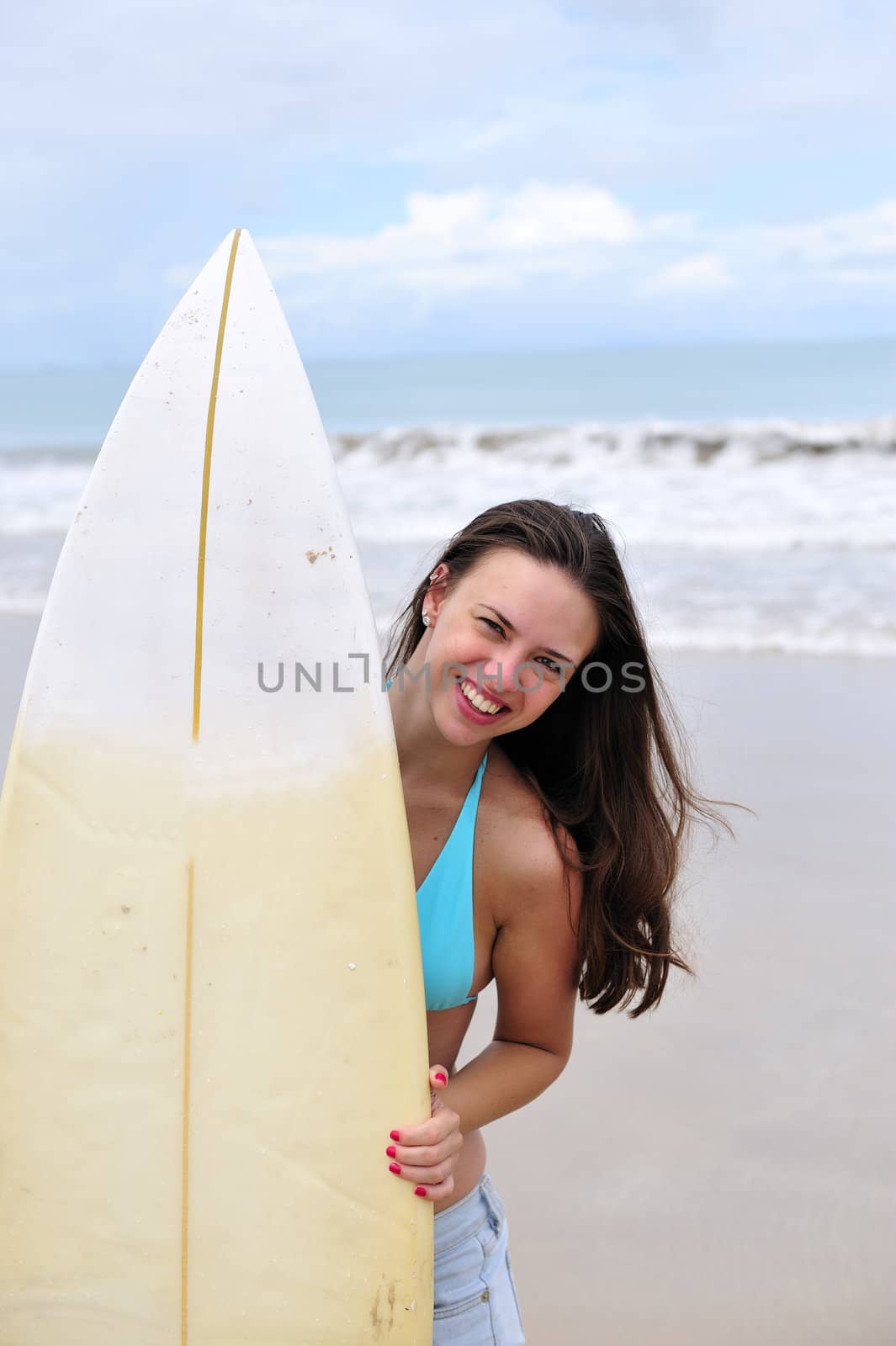 Surf girl holding a board in Brazil
