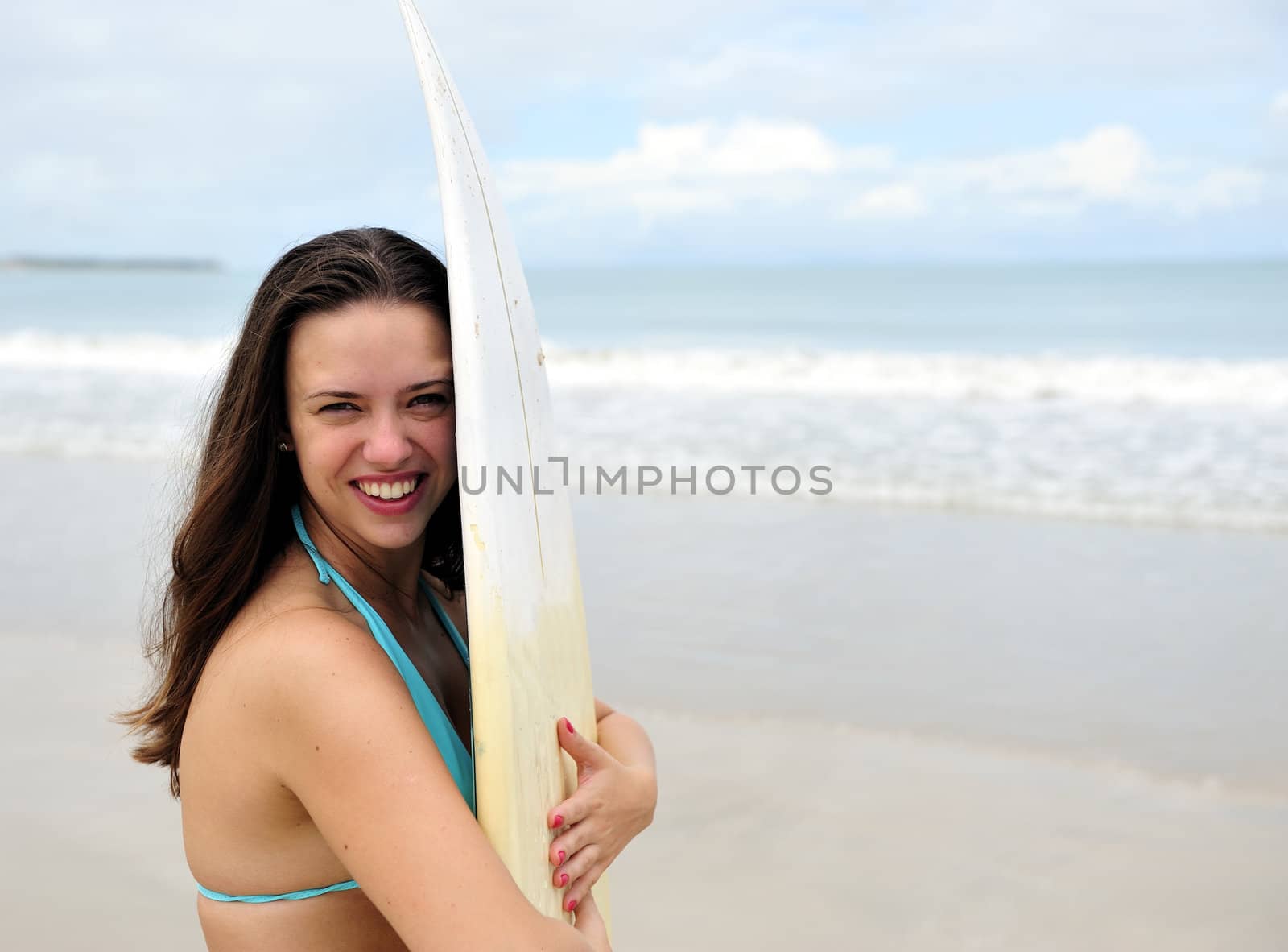 Surf girl holding a board in Brazil
