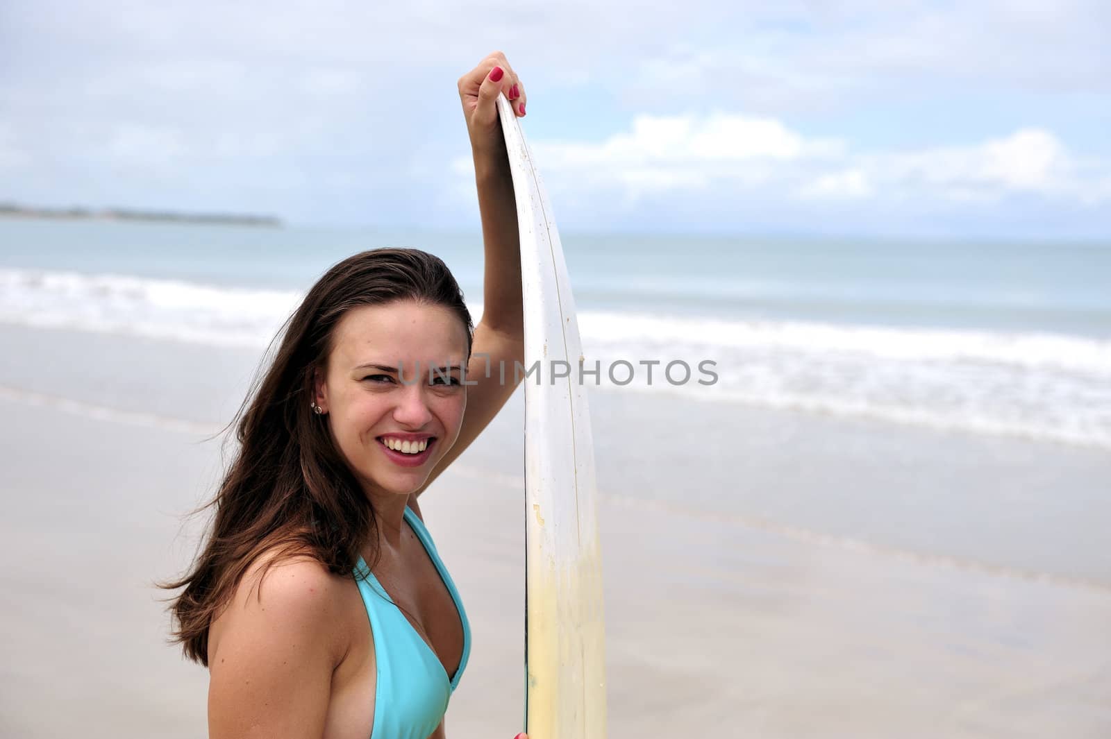 Surf girl holding a board in Brazil
