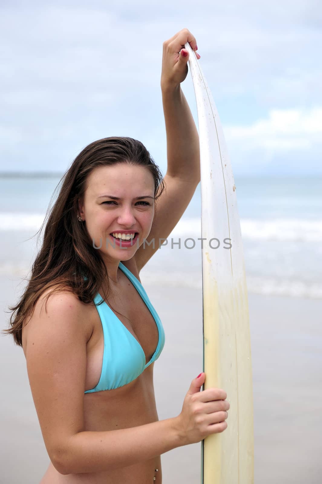 Surf girl holding a board in Brazil
