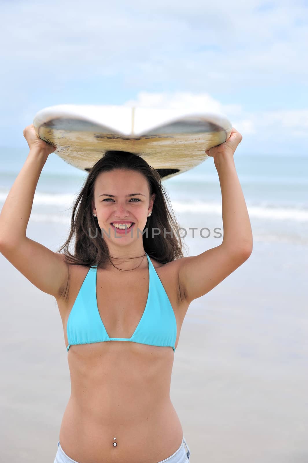 Surf girl holding a board in Brazil
