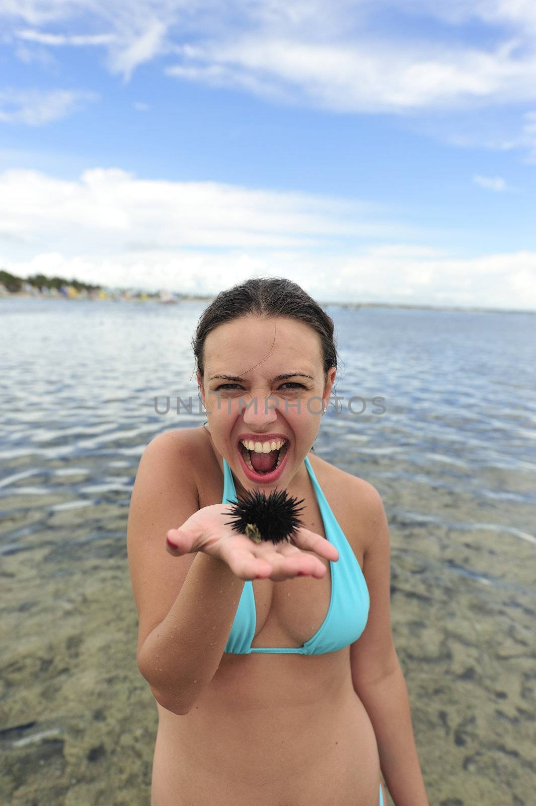 Woman holding an urchin on the beach in Brazil
