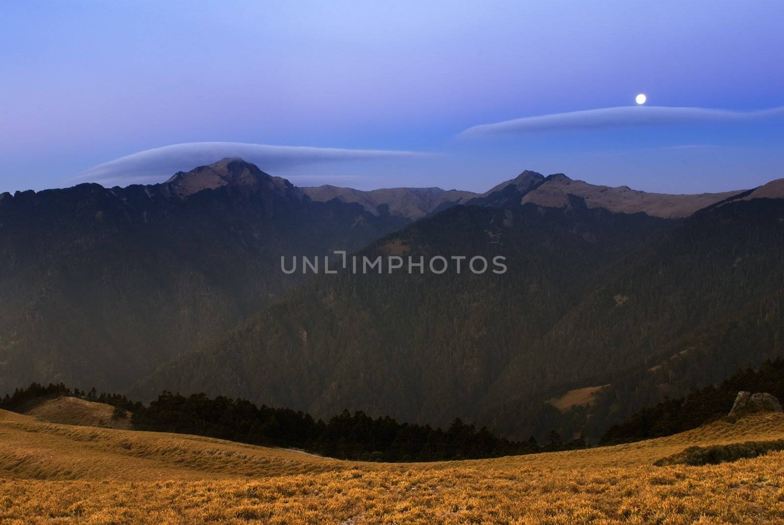 Moon rised and shining over the high mountain.