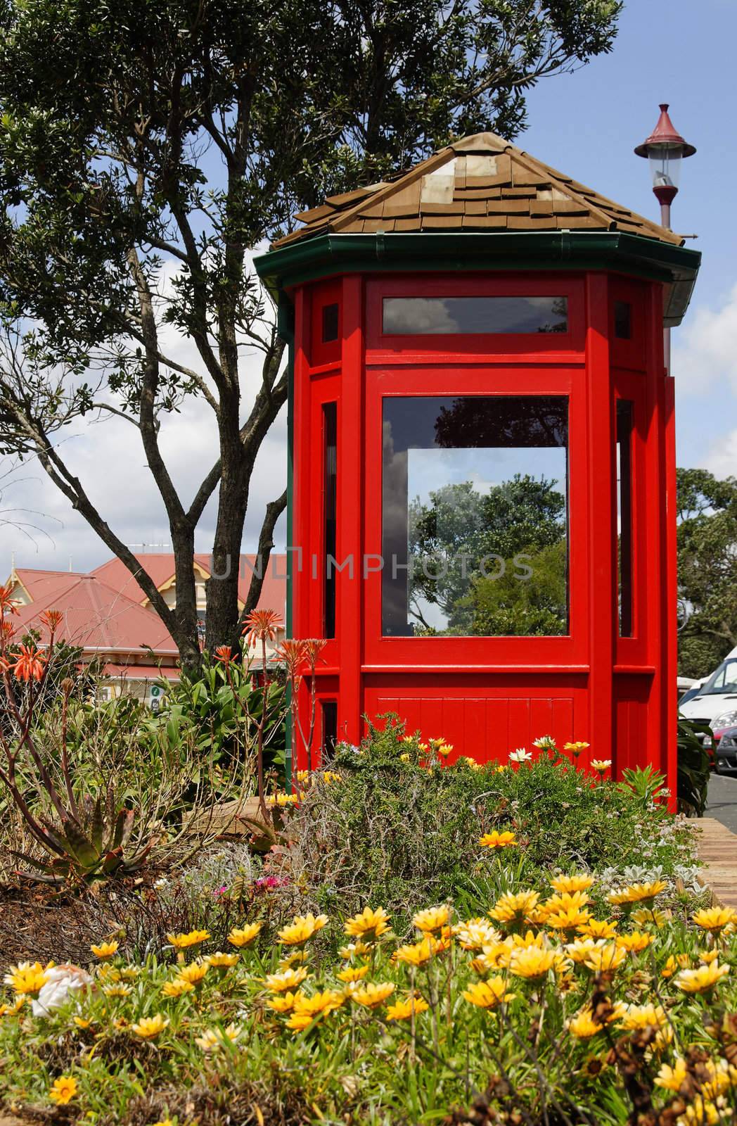 British style telephone booth surrounded  by flowers by garymkrieg
