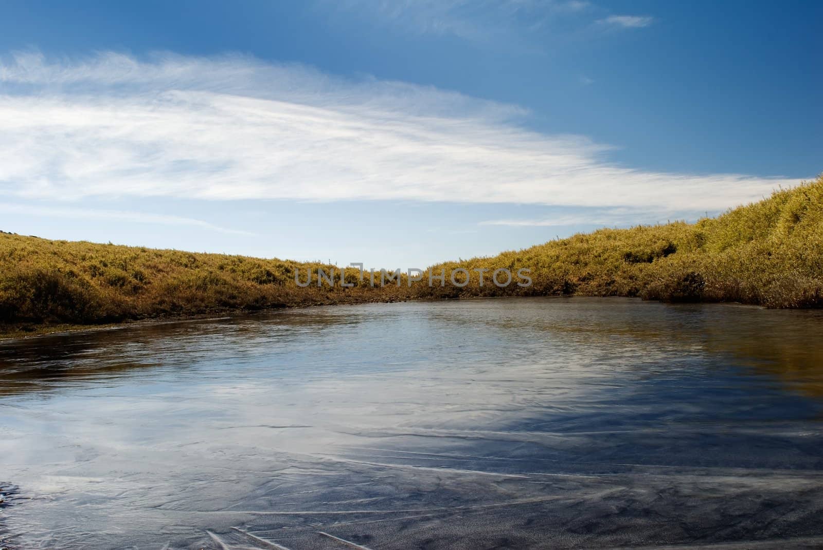 Beautiful iced pond surface and blue sky. by elwynn