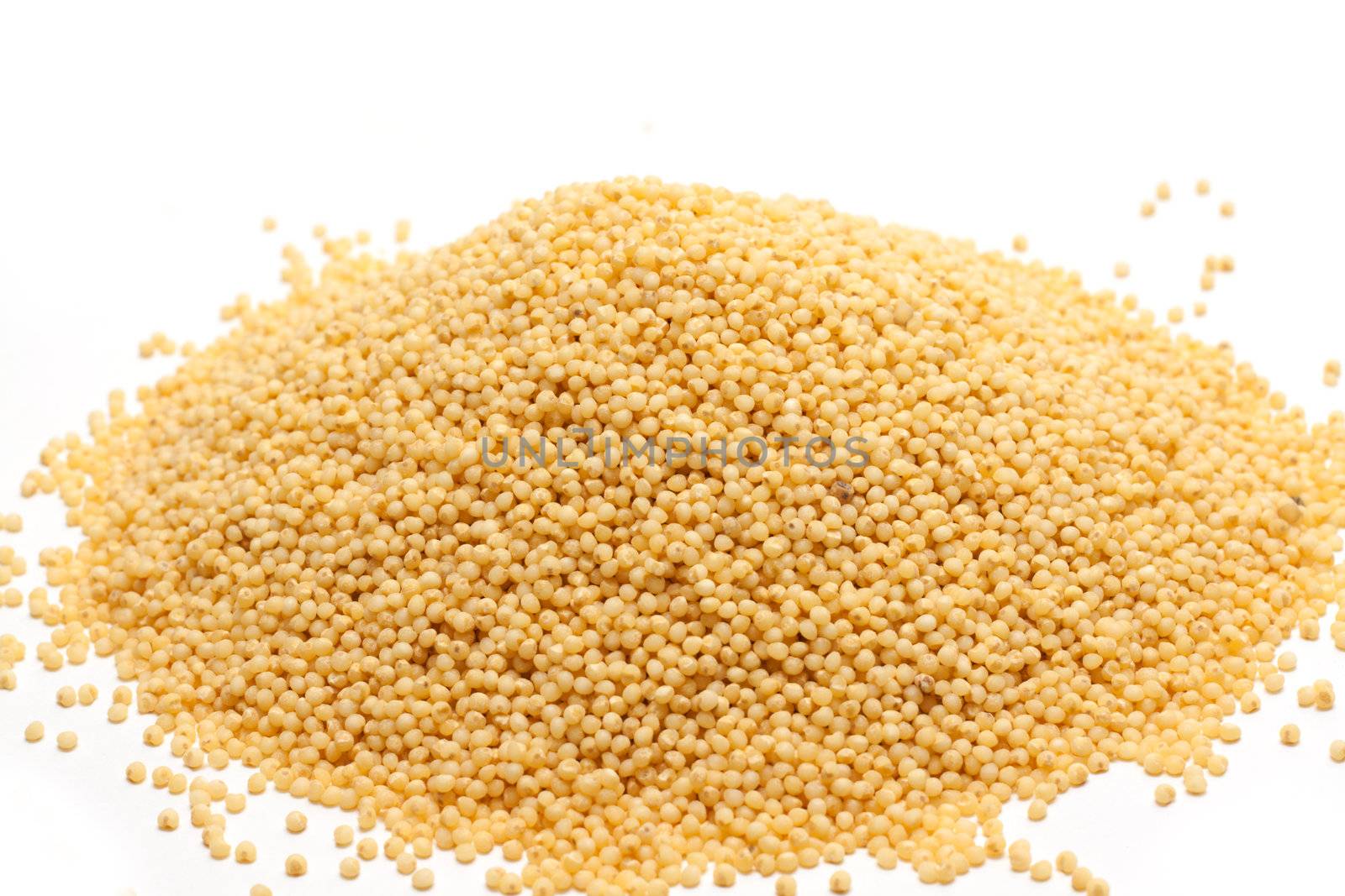 Heap millet is spilt on white background
