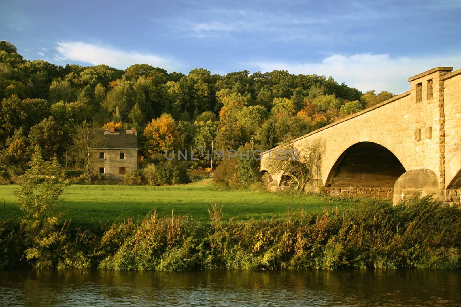 The beautiful bridge through the river and the old house