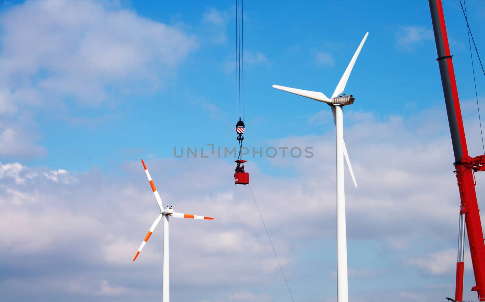 People make repairs wind turbines with the help of a crane