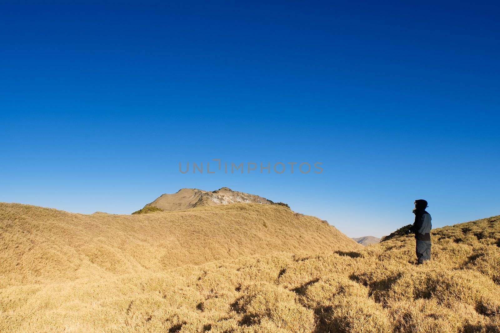 A man stand on the mountain with golden sunshine.