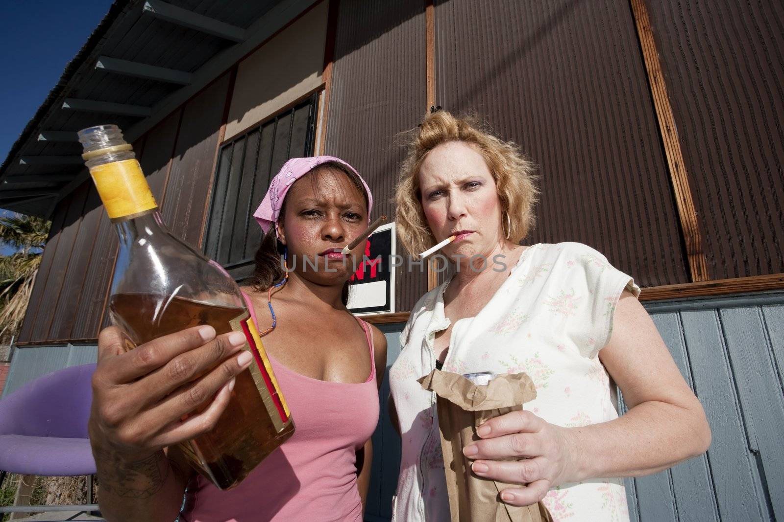 Portrait of two trashy drunk women outdoors