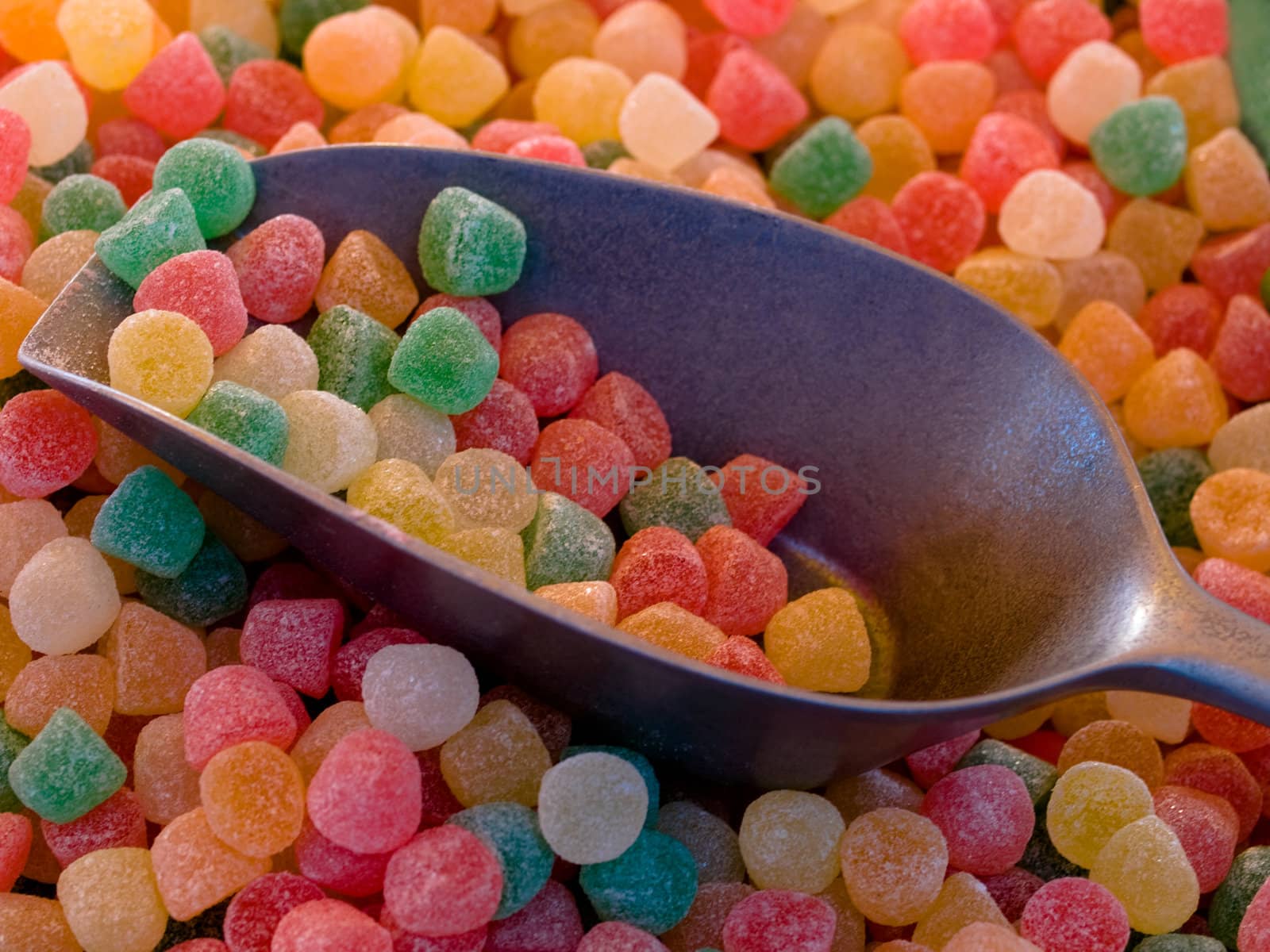 multicolored candies with metallic spoon macro