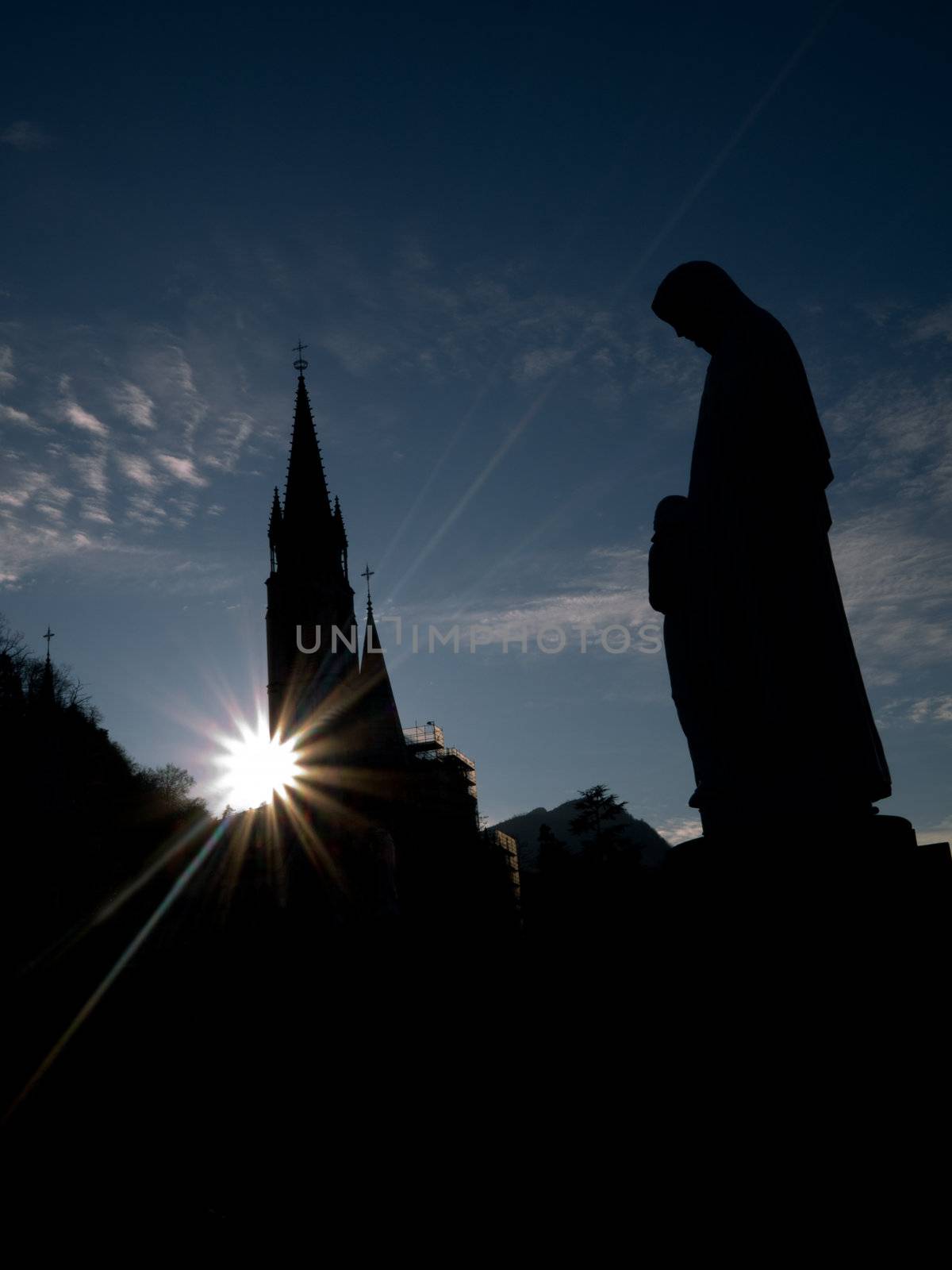 Silhouette of the Basilica of the Immaculate Conception in Lourdes with statue of the virgin Mary