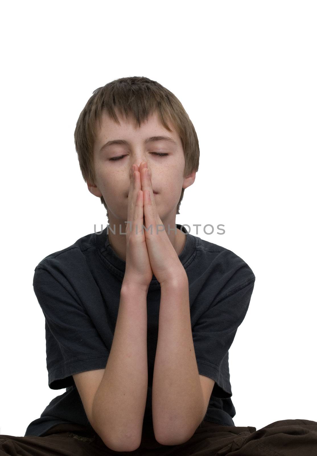 an isolated image of a you boy / teen praying with his eye closed.