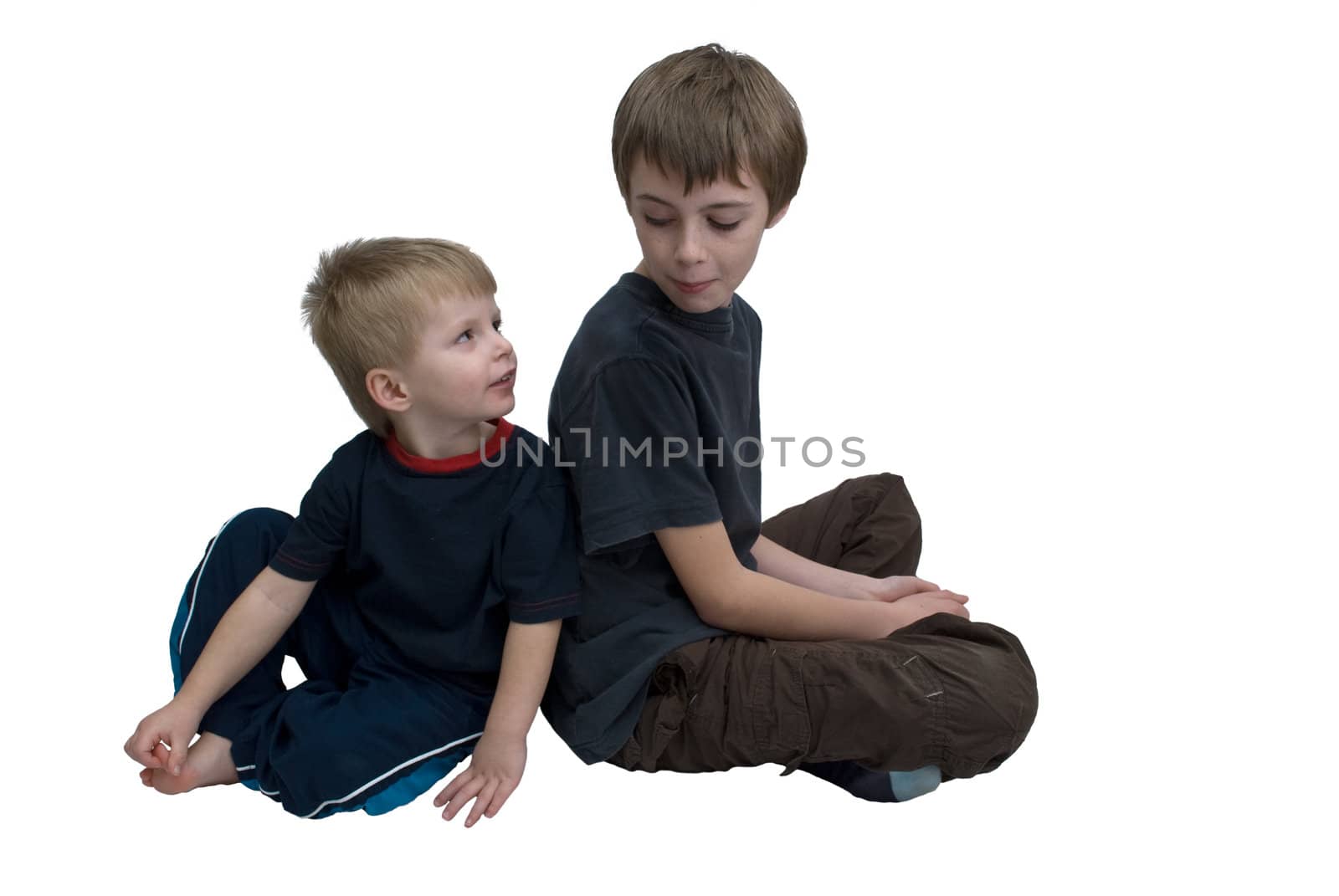 Two brothers sitting back to back looking towards each other, isolated.