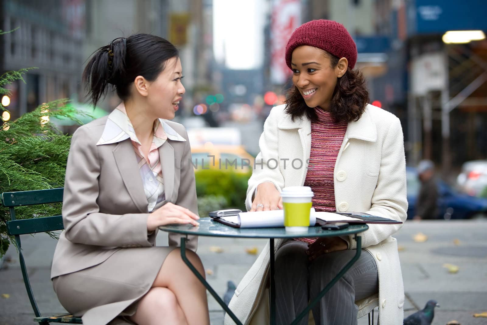 Two business women having a casual meeting or discussion in the city. 